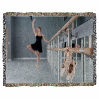 Pointe shoes hang on ballet barre in dance class room. Blurred